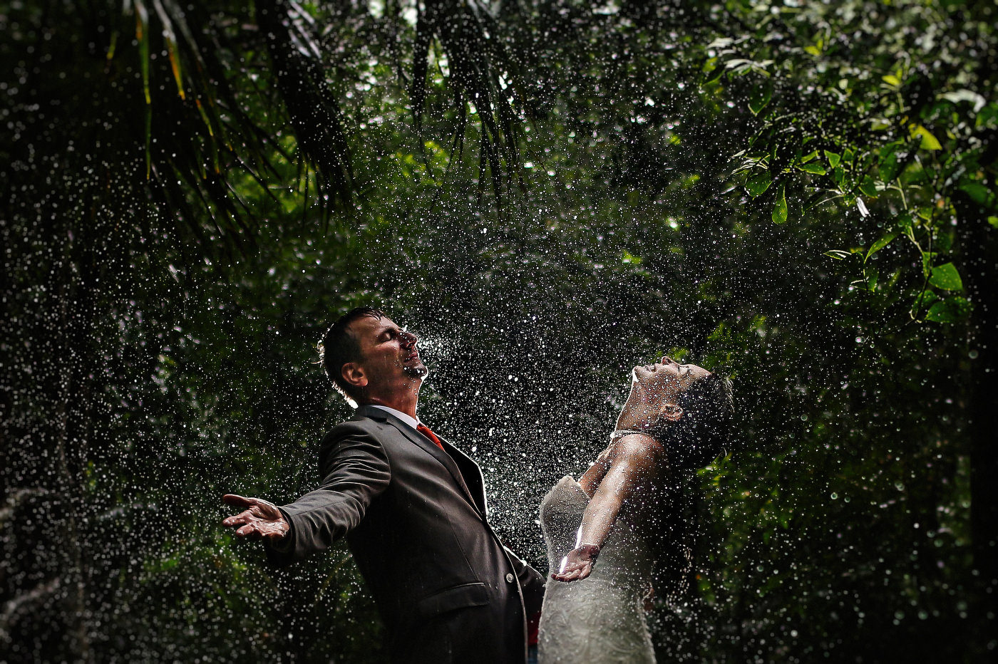Bride and groom shot under in the rain during Cenote Trash the Dress Session in Mexico. Jhankarlo Photography